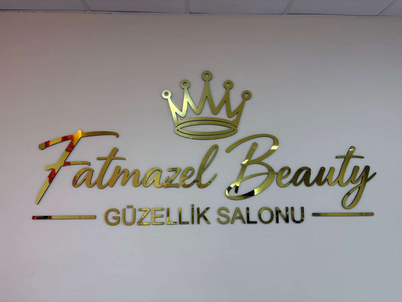 Altın taçlı Fatmazel Beauty Güzellik Salonu logo duvarı